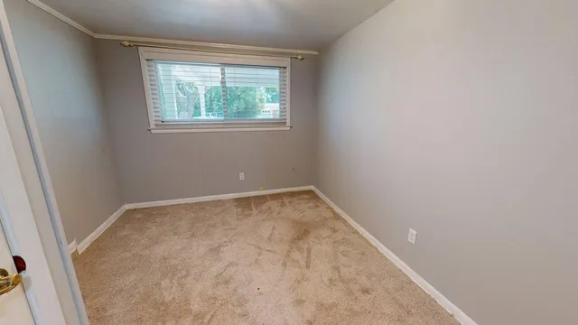 a view of an empty room with a fireplace and a window