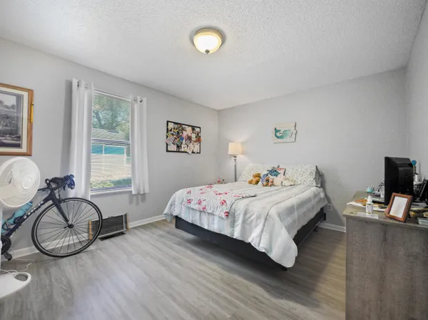 a bedroom with a bed and wooden floor