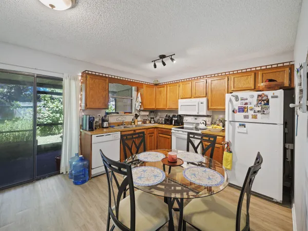 a dining room with stainless steel appliances a table and chairs
