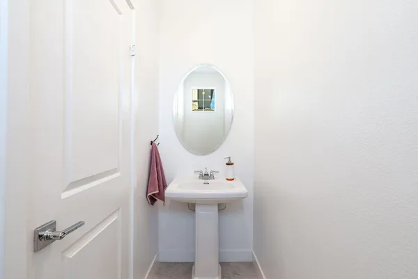 a view of a hallway with wooden floor and a living room