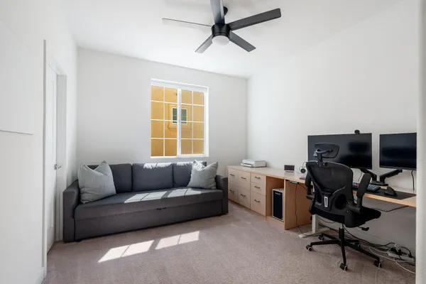 a view of a workspace with furniture and a window
