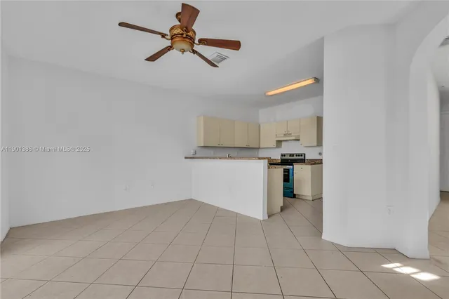 a view of a kitchen with a sink and dishwasher a refrigerator with white cabinets
