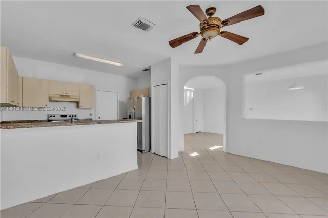 a view of a kitchen with a sink and a refrigerator