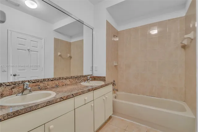a bathroom with a granite countertop sink a mirror and a bathtub
