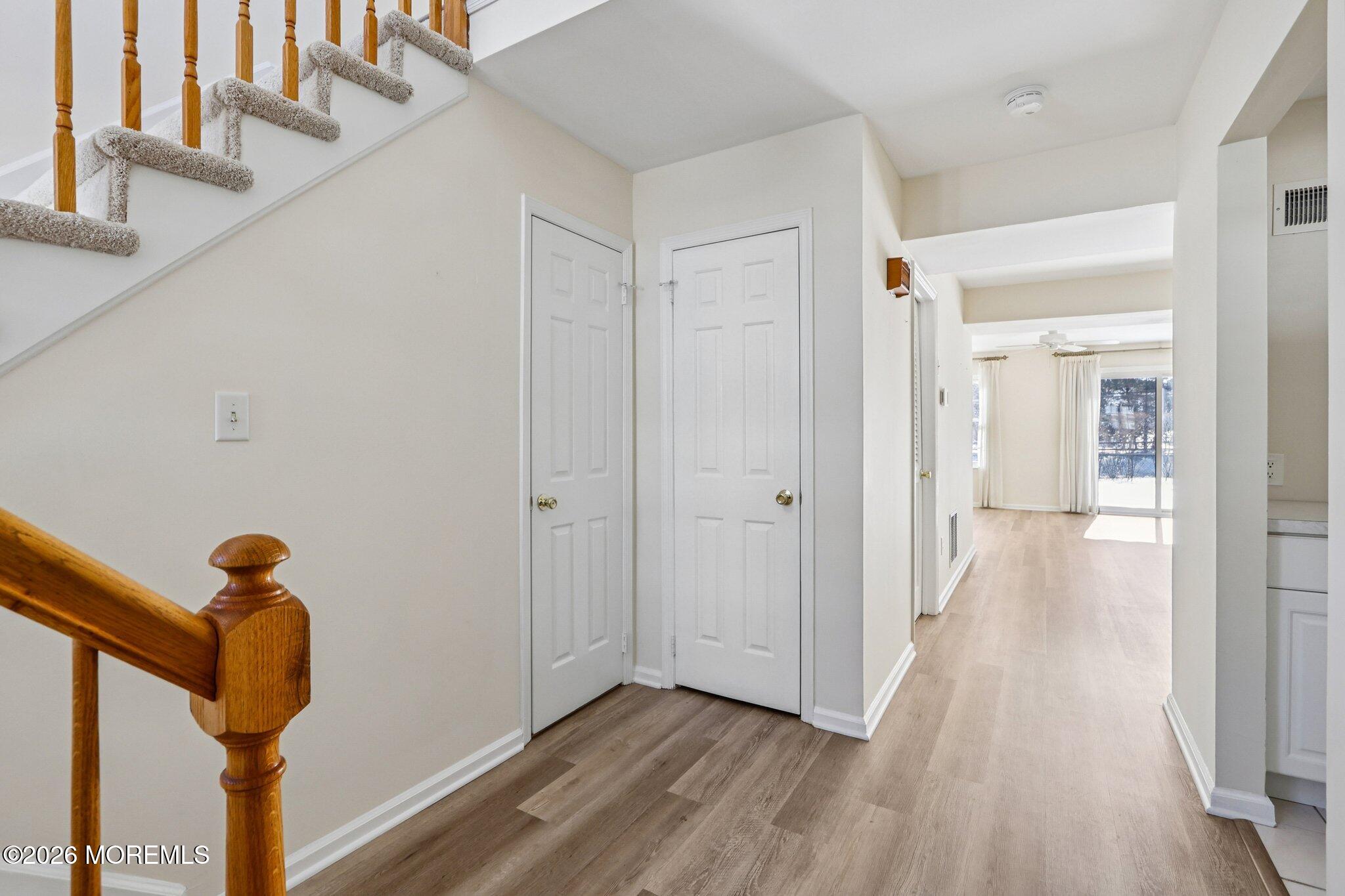 a view of a hallway with wooden floor and staircase