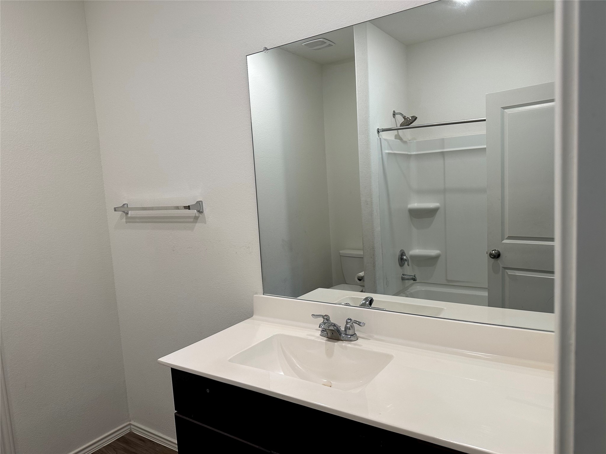13501 Mussel Run Elgin, TX 78621 - Photo 12 of 28 Bathroom vanity featuring a single basin sink, white countertop, and dark cabinetry