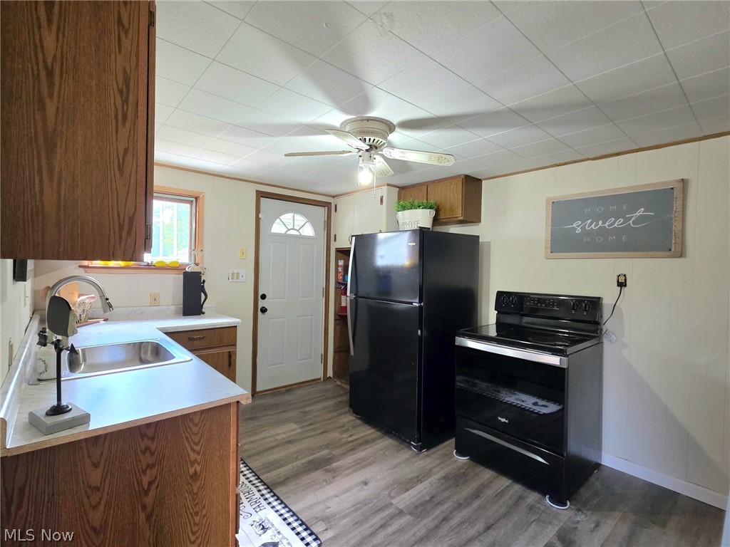 2335 West River Road Newton Falls, OH 44444 - Photo 11 of 36 Kitchen featuring wood-finish cabinetry, light-toned countertops, a stainless steel sink, and wood-look flooring