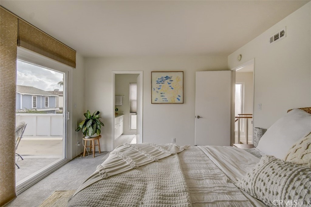 401 Canal Street Newport Beach, CA 92663 - Photo 16 of 27 a bedroom with a large bed and wooden floor