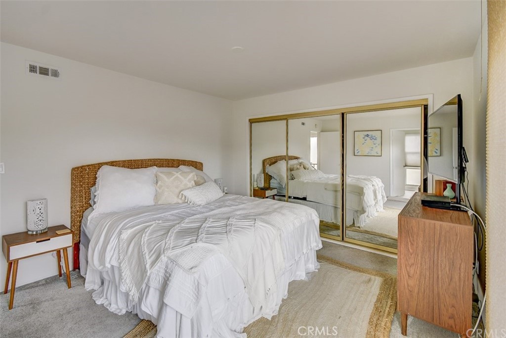 401 Canal Street Newport Beach, CA 92663 - Photo 18 of 27 a bedroom with a bed and large mirror