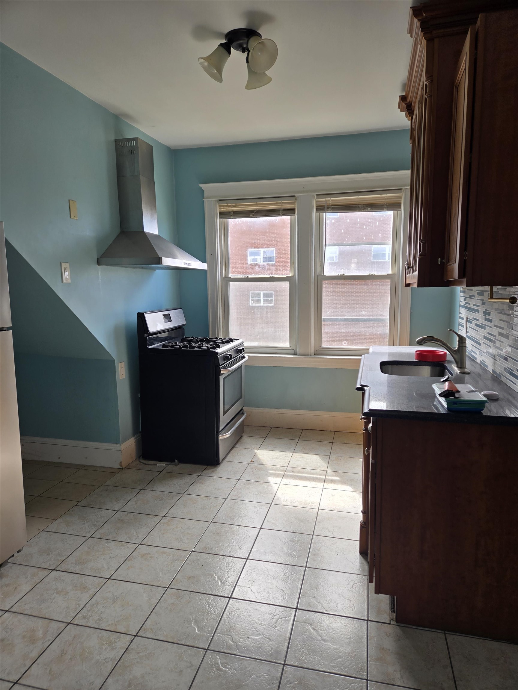 1205 73rd Street, Unit 2 North Bergen, NJ 07047 - Photo 3 of 8 a kitchen with granite countertop a sink and a stove