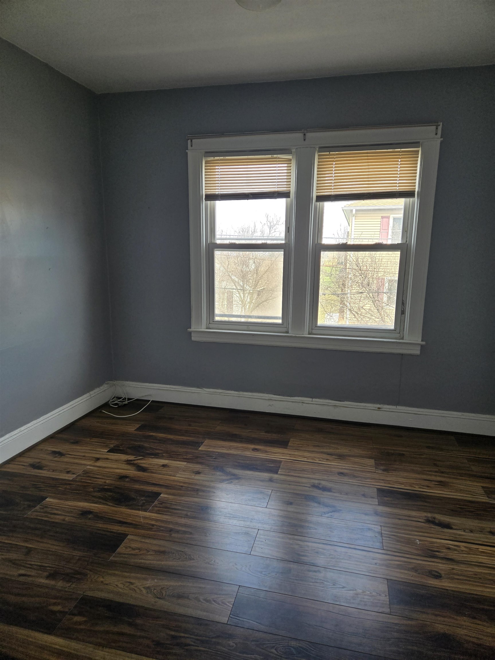 1205 73rd Street, Unit 2 North Bergen, NJ 07047 - Photo 5 of 8 a view of an empty room with wooden floor and a window