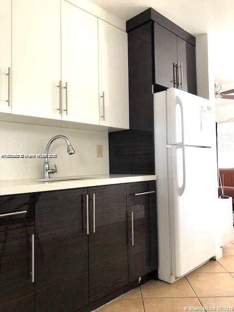 904 Southwest 7th Terrace, Unit 1 Hallandale Beach, FL 33009 - Photo 2 of 11 a kitchen with a refrigerator and cabinets