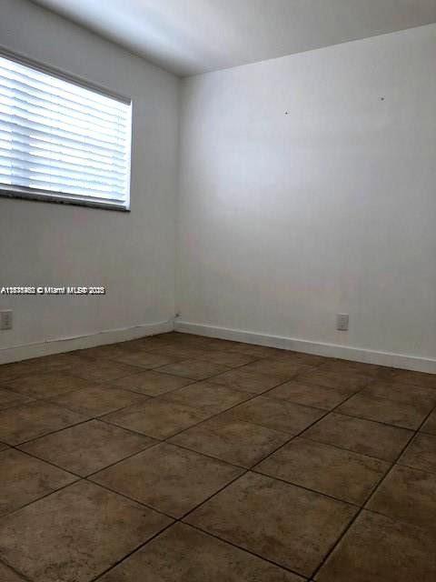 904 Southwest 7th Terrace, Unit 1 Hallandale Beach, FL 33009 - Photo 5 of 11 an empty room with a window