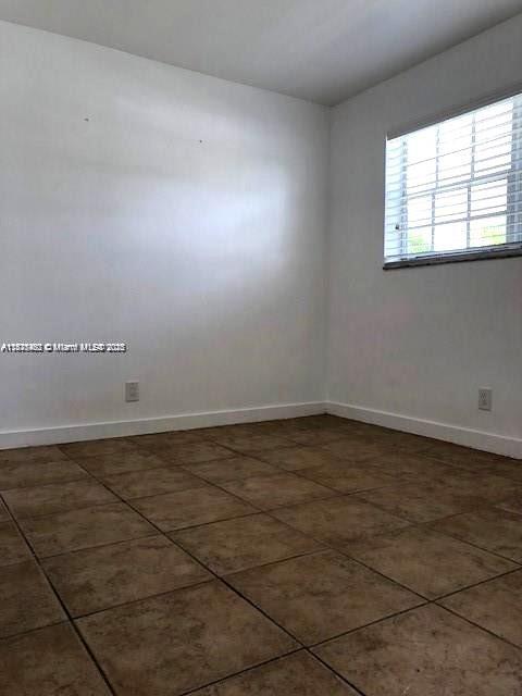 904 Southwest 7th Terrace, Unit 1 Hallandale Beach, FL 33009 - Photo 7 of 11 an empty room with wooden floor and windows