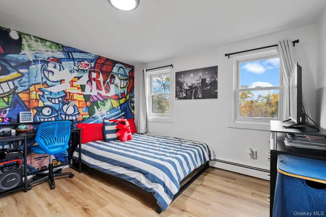 a bedroom with a bed a dresser next to a window