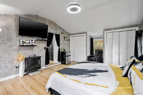 a bedroom with a bed and a flat tv screen on wall