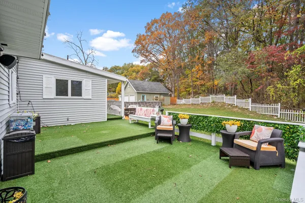 a view of a house with backyard and sitting area