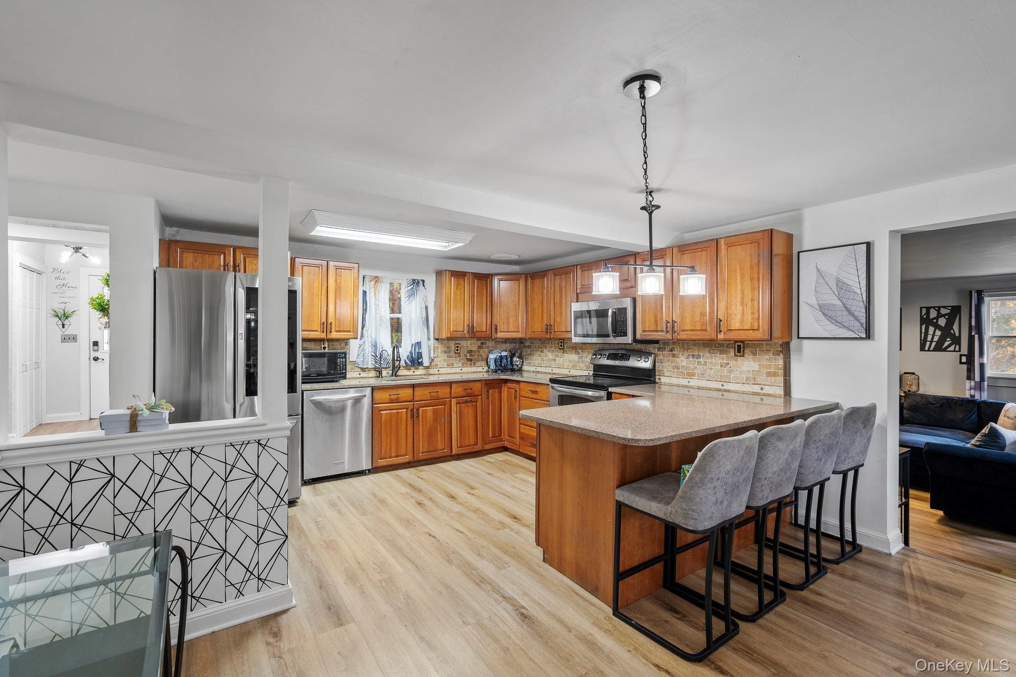 168 Fostertown Road Newburgh, NY 12550 - Photo 6 of 37 a kitchen with stainless steel appliances granite countertop a stove a sink dishwasher a dining table and chairs with wooden floor