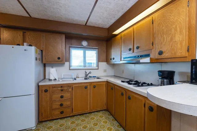 a kitchen with a sink a stove and cabinets