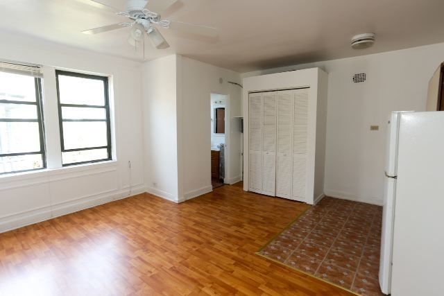 4735 North Beacon Street, Unit 211 Chicago, IL 60640 - Photo 7 of 11 a view of an empty room with wooden floor and a window