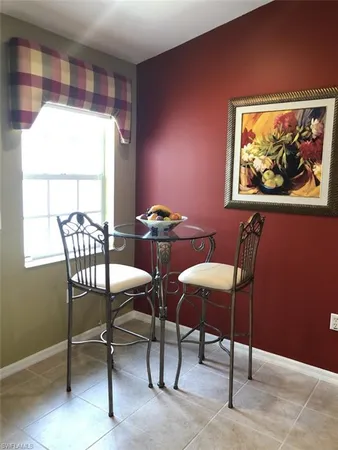 a view of a dining room with furniture a rug and a window