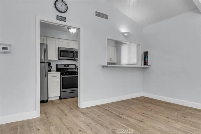 a kitchen with white cabinets and stainless steel appliances