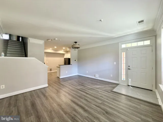 a view of a big room with wooden floor and windows