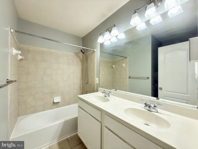 a bathroom with a tub a sink and a mirror