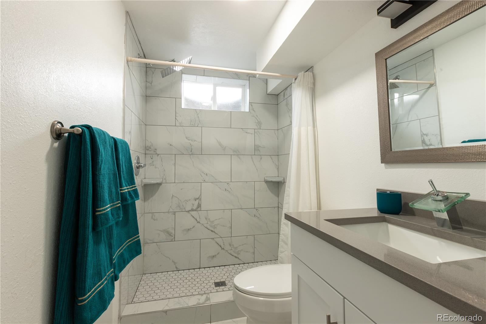 8243 Adams Way Denver, CO 80221 - Photo 12 of 27 a bathroom with a granite countertop sink toilet and shower