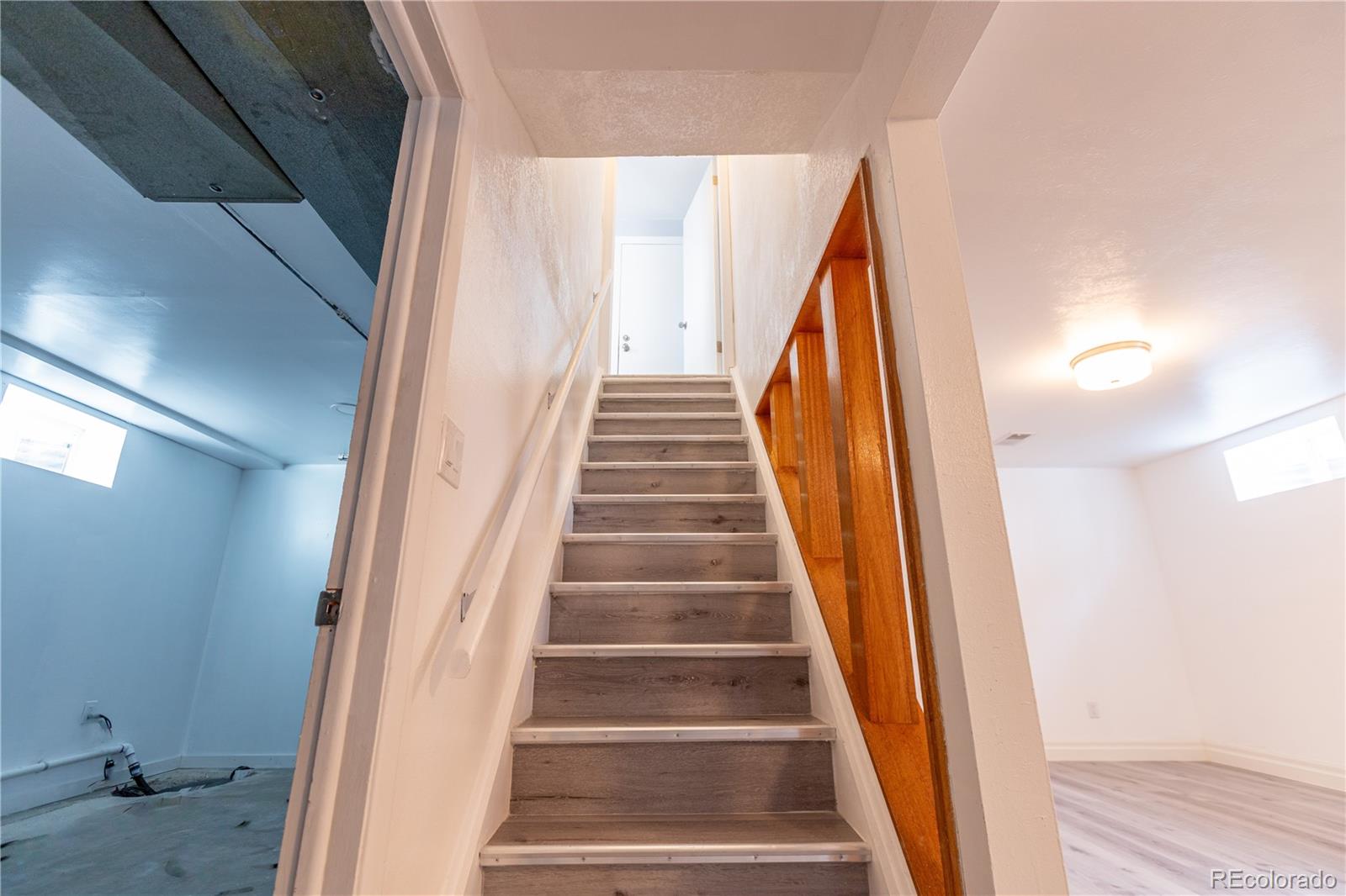 8243 Adams Way Denver, CO 80221 - Photo 17 of 27 a view of staircase with wooden floor and white walls
