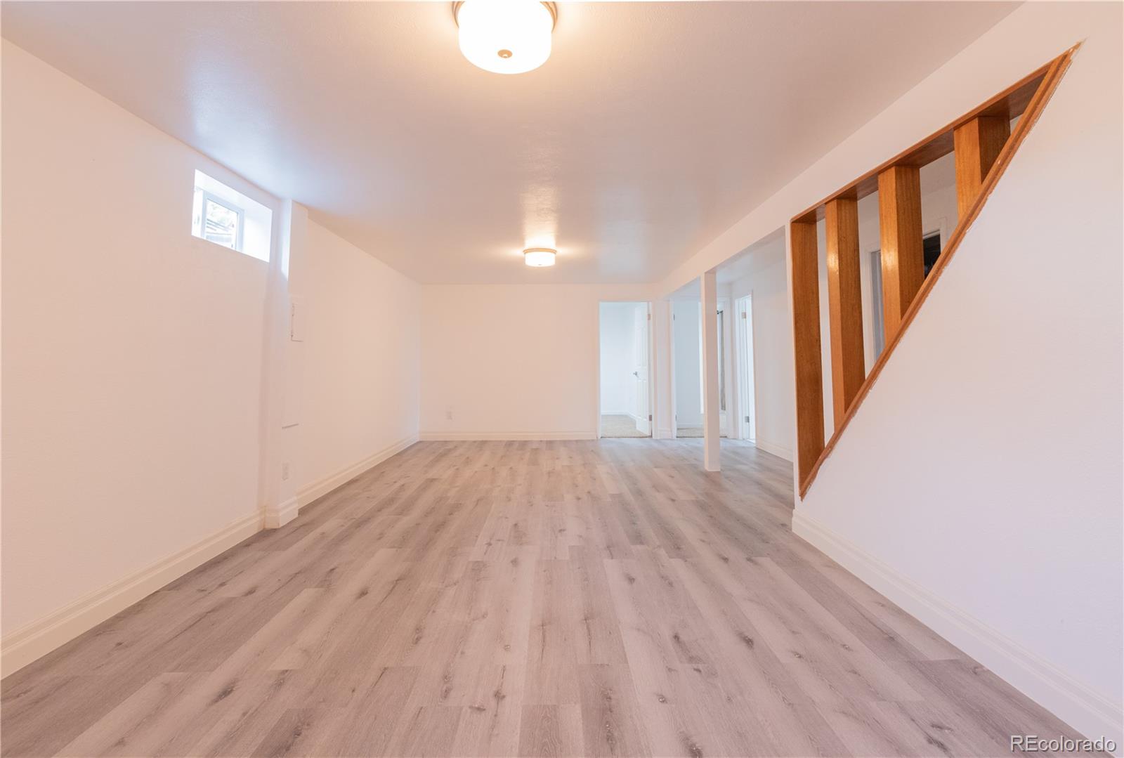 8243 Adams Way Denver, CO 80221 - Photo 18 of 27 a view of a hallway with wooden floor and staircase