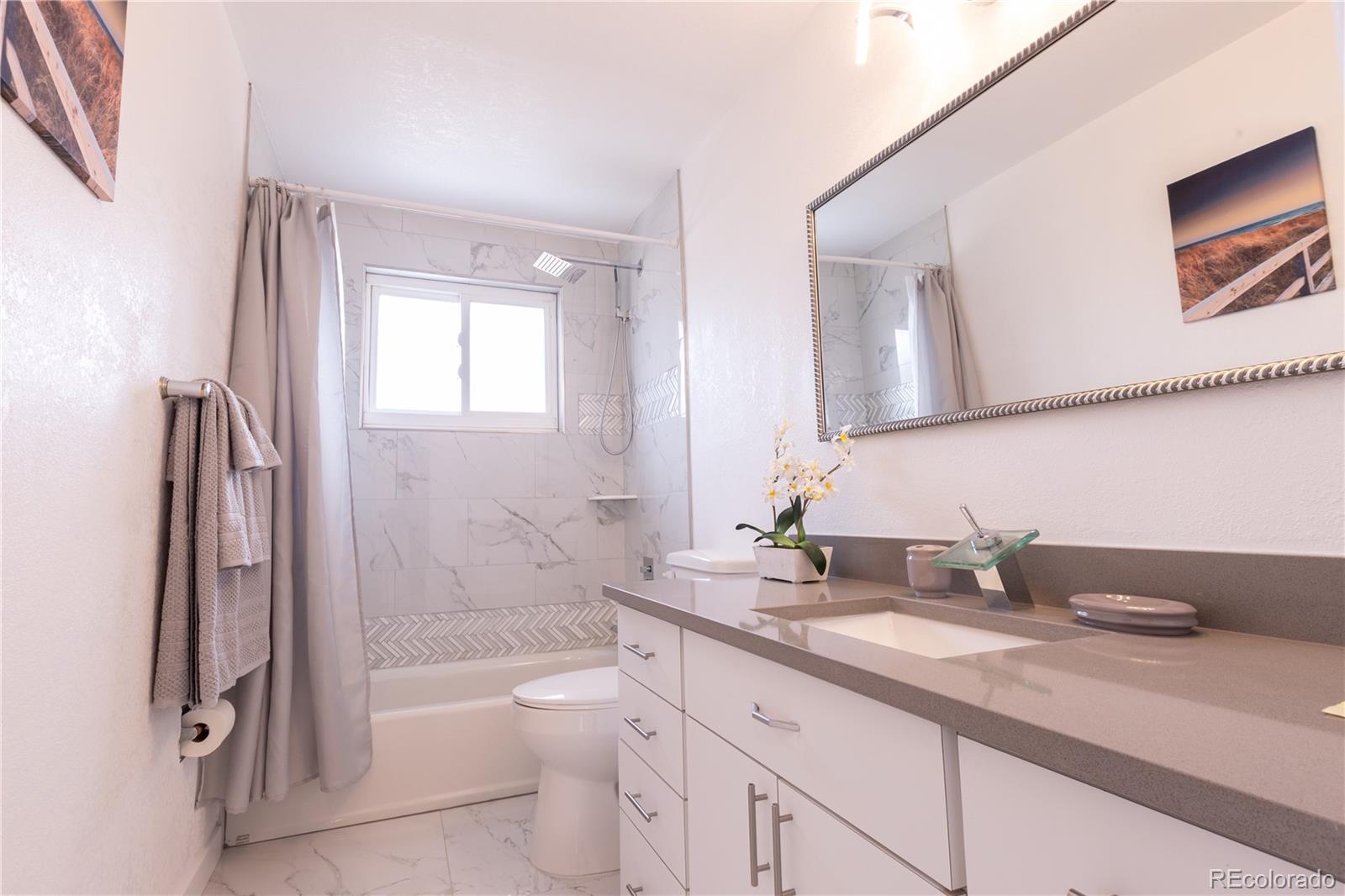 8243 Adams Way Denver, CO 80221 - Photo 20 of 27 a bathroom with a granite countertop sink toilet and shower