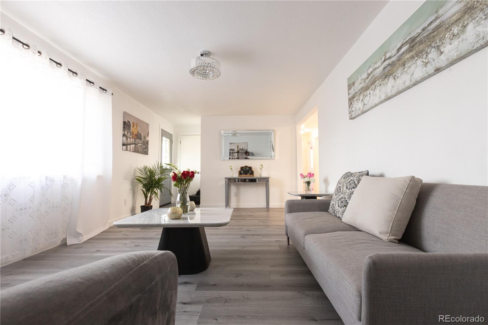 8243 Adams Way Denver, CO 80221 - Photo 2 of 27 a living room with furniture and a wooden floor