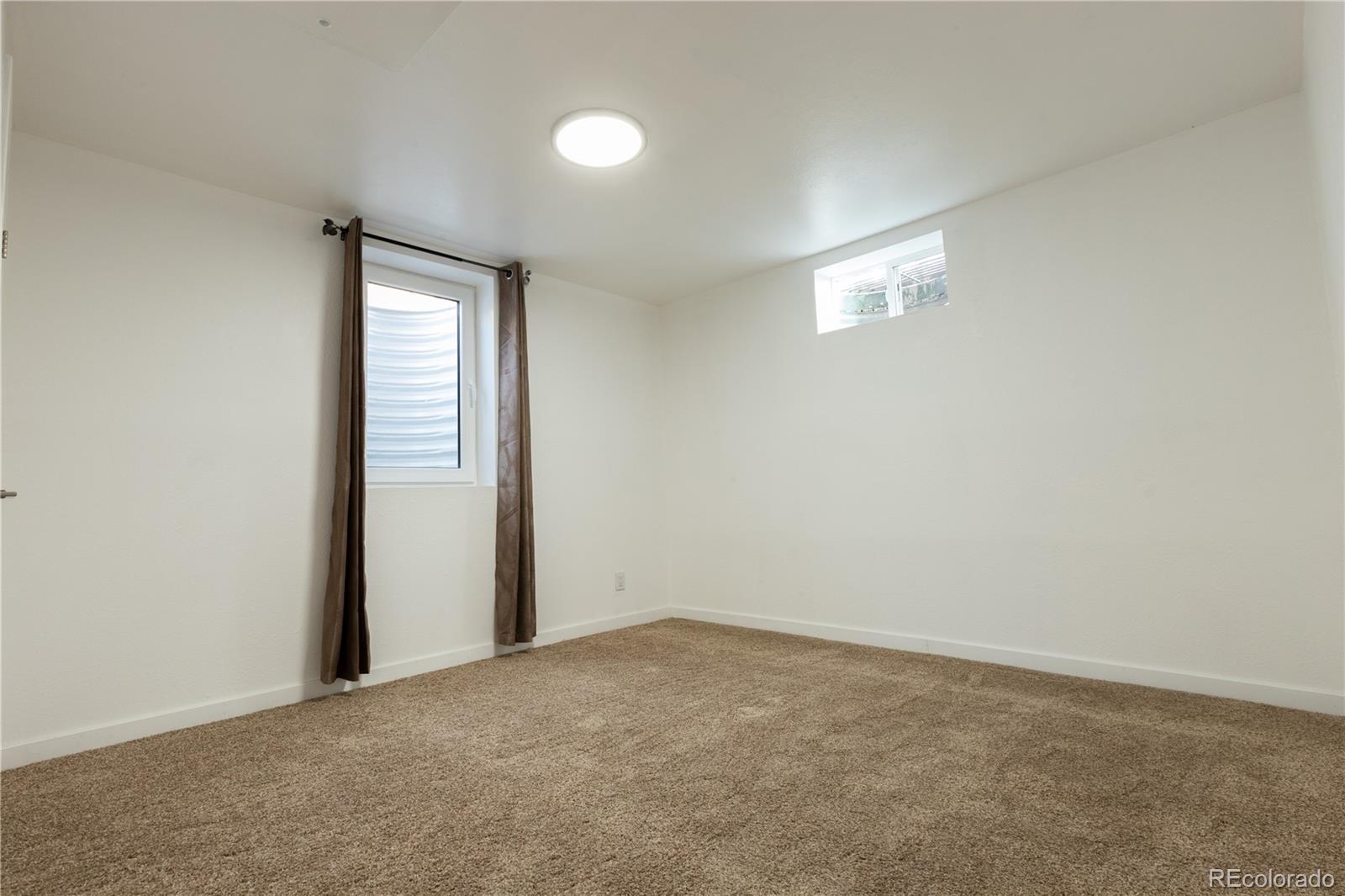 8243 Adams Way Denver, CO 80221 - Photo 23 of 27 an empty room with windows and closet