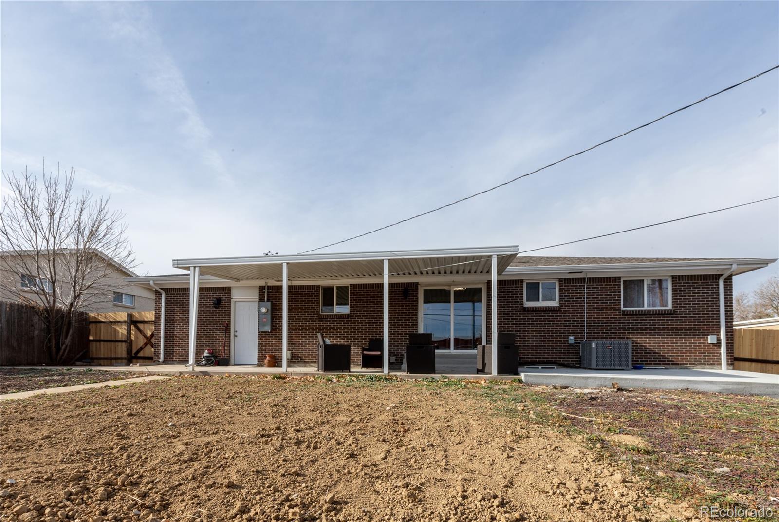 8243 Adams Way Denver, CO 80221 - Photo 26 of 27 a view of a house with a backyard and windows