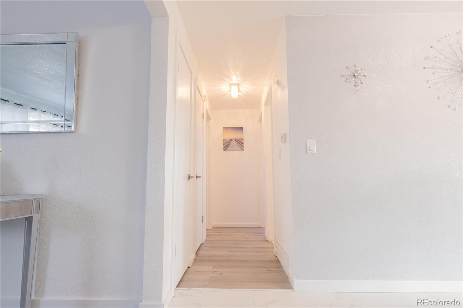 8243 Adams Way Denver, CO 80221 - Photo 10 of 27 a view of a hallway with wooden floor
