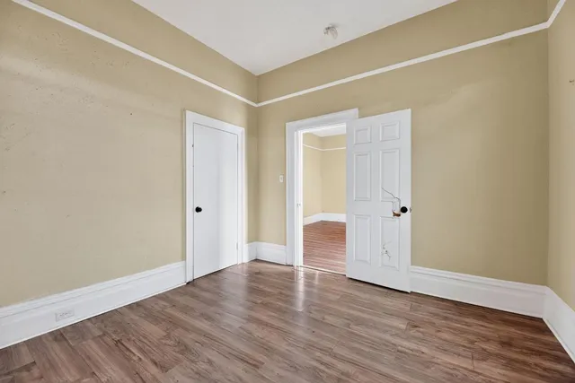 a view of an empty room with wooden floor
