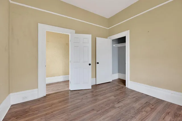 an empty room with wooden floor and closet