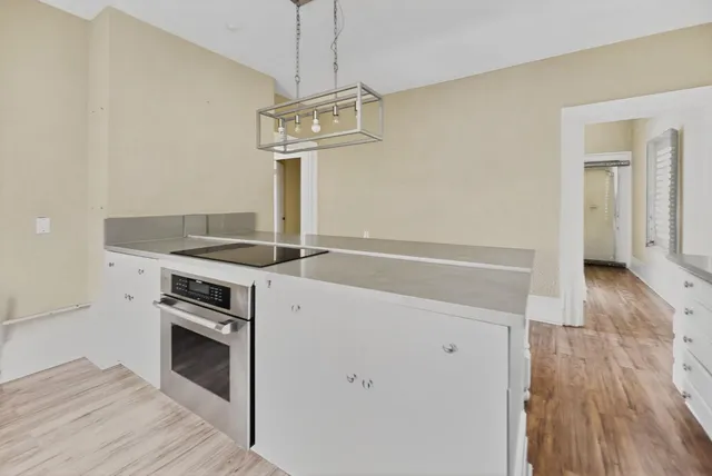 a kitchen with a stove and a wooden floor