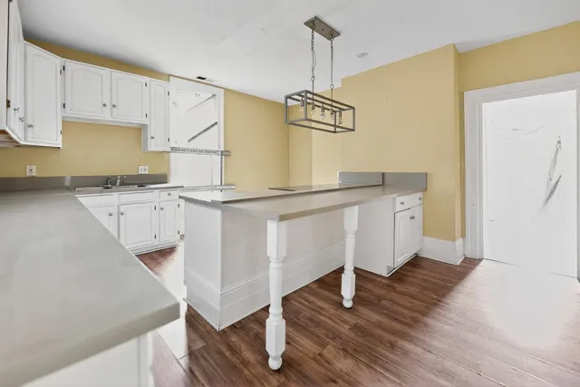 a kitchen with cabinets and wooden floor