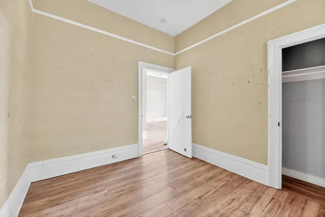 a view of an empty room with wooden floor