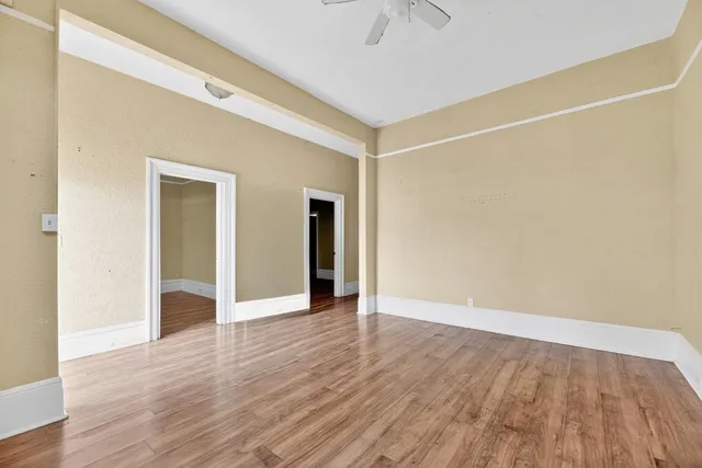 a view of an empty room with wooden floor