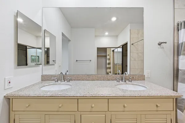 a bathroom with a granite countertop sink and a mirror
