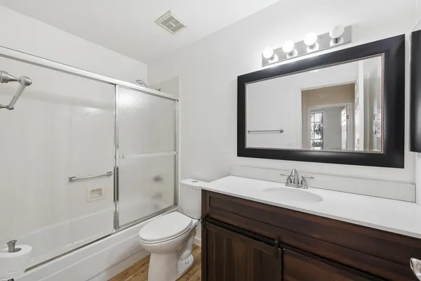 a bathroom with a sink a toilet a mirror and shower