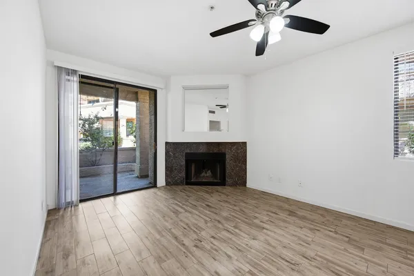 a view of an empty room with window and fire place