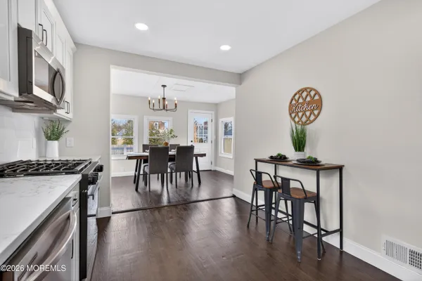a view of a a dining room with furniture window and wooden floor