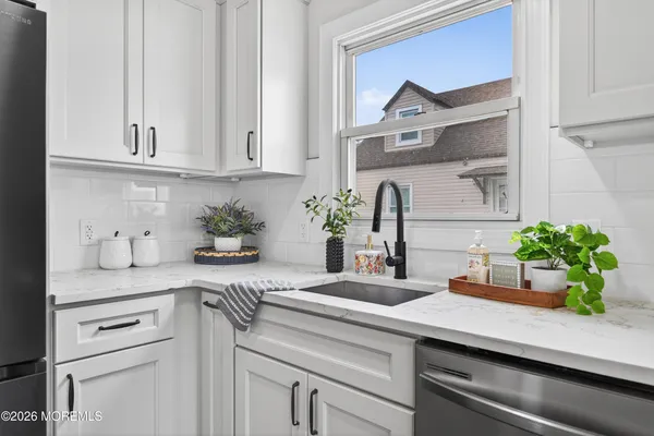 a kitchen with white cabinets and a potted plant