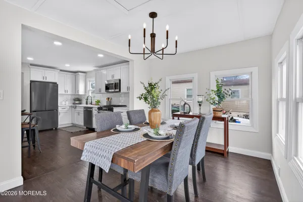 a view of a dining room with furniture a chandelier and wooden floor
