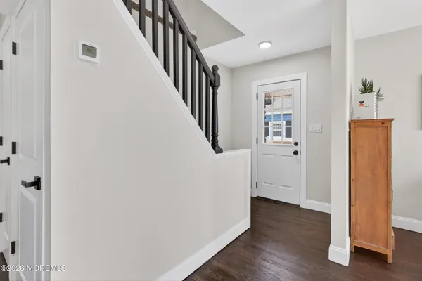 a view of a hallway with wooden floor and entryway