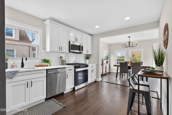 a kitchen with white cabinets and stainless steel appliances